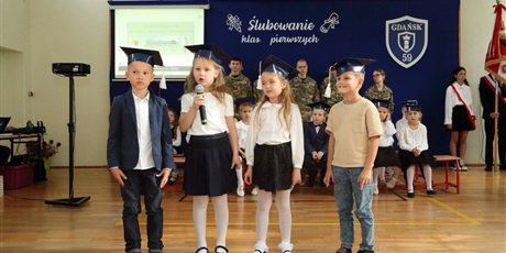 Powiększ grafikę: Uczniowie w sali gimnastycznej podczas pasowania na ucznia.