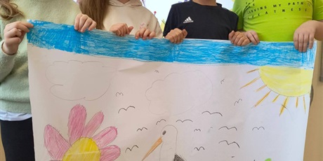 Powiększ grafikę: Uczniowie prezentują plakat o wiośnie.