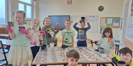 Powiększ grafikę: Uczniowie sadzą rosliny w doniczkach w sali lekcyjnej.