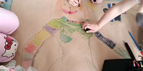 Powiększ grafikę: Uczniowie rysują plakat o wiośnie w sali lekcyjnej.