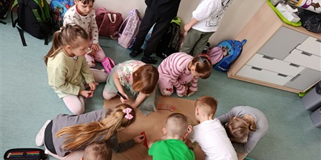 Powiększ grafikę: Uczniowie rysują plakat o wiośnie w sali lekcyjnej.