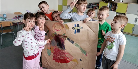 Powiększ grafikę: Uczniowie prezentują plakat o wiośnie.