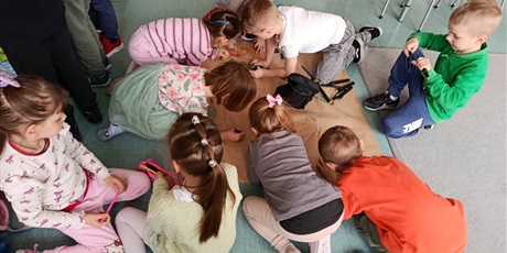 Powiększ grafikę: Uczniowie rysują plakat o wiośnie w sali lekcyjnej.