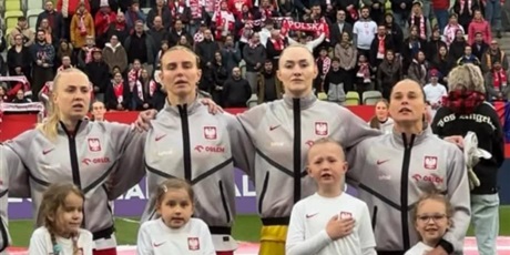 Powiększ grafikę: Reprezentantki Polski oraz  dzieci podczas hymnu narodowego przed meczem na stadionie.