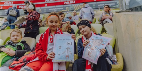Powiększ grafikę: Uczniowie na trybunach stadionu piłkarskiego.