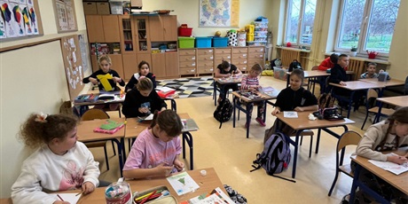 Powiększ grafikę: Uczniowie w sali lekcyjnej wykonują kartki świąteczne.