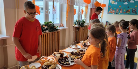 Powiększ grafikę: Uczniowie na kiermaszu "Tumbo Pomaga" na korytarzu szkolnym.