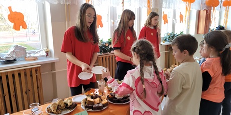 Powiększ grafikę: Uczniowie na kiermaszu "Tumbo Pomaga" na korytarzu szkolnym.