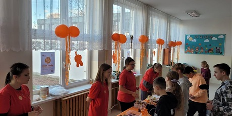 Powiększ grafikę: Uczniowie na kiermaszu "Tumbo Pomaga" na korytarzu szkolnym.