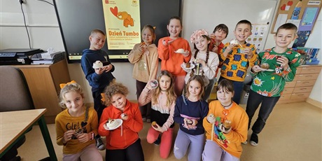 Powiększ grafikę: Zbiorowe zdjęcie uczniów w dniu  kiermaszu "Tumbo Pomaga"  w sali lekcyjnej.