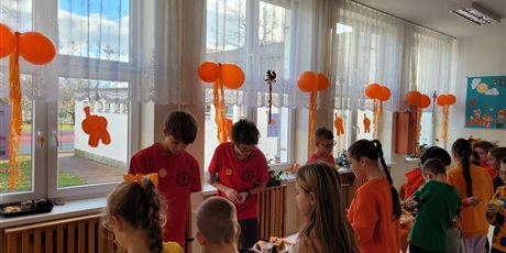 Powiększ grafikę: Uczniowie na kiermaszu "Tumbo Pomaga" na korytarzu szkolnym.