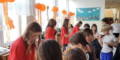 Powiększ grafikę: Uczniowie na kiermaszu "Tumbo Pomaga" na korytarzu szkolnym.