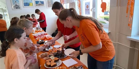 Powiększ grafikę: Uczniowie na kiermaszu "Tumbo Pomaga" na korytarzu szkolnym.