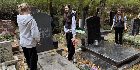 Powiększ grafikę: Uczniowie porządkują groby na cmentarzu.