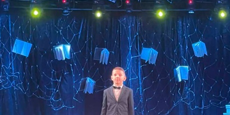 Powiększ grafikę: Uczeń podczas recytacji na scenie konkursowej.