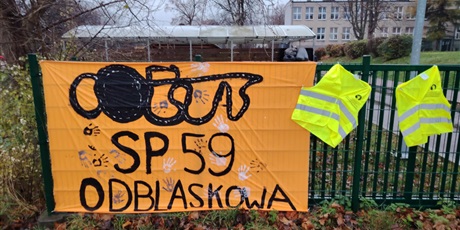 Powiększ grafikę: Plakat na ogrodzeniu szkoły o treści: "SP 59 odblaskowa".