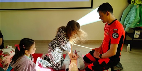 Powiększ grafikę: Uczniowie i ratownik medyczny podczas zajęć z pierwszej pomocy.