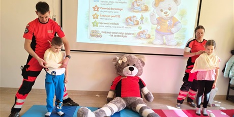 Powiększ grafikę: Uczniowie i ratownicy medyczni podczas zajęć z pierwszej pomocy.