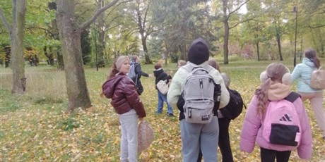 Powiększ grafikę: Uczniowie spacerują po parku.