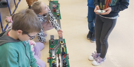 Powiększ grafikę: Uczniowie układają tory z klocków w sali lekcyjnej.