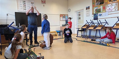 Powiększ grafikę: Uczniowie układają tory z klocków w sali lekcyjnej.