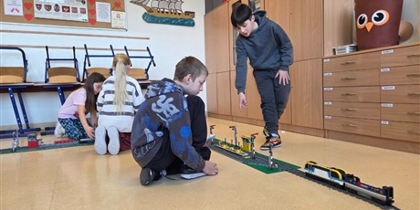 Powiększ grafikę: Uczniowie układają tory z klocków w sali lekcyjnej.