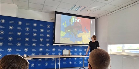 Powiększ grafikę: Prowadząca warsztaty , w tle mapa Europy w sali wykładowej