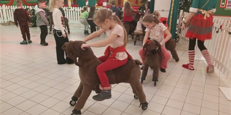 Powiększ grafikę: Uczniowie podczas zabawy na reniferach.