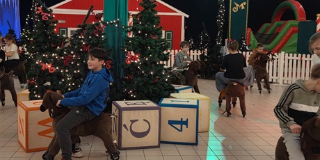 Powiększ grafikę: Uczniowie podczas zabawy na reniferach.