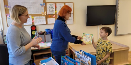 Powiększ grafikę: Pani wicedyrektor w towarzystwie nauczycielki wręcza uczniowi nagrodę .