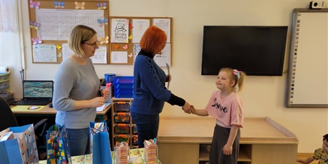 Powiększ grafikę: Pani wicedyrektor w towarzystwie nauczycielki wręcza uczennicy nagrodę .