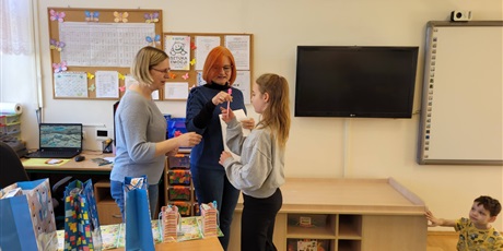 Powiększ grafikę: Pani wicedyrektor w towarzystwie nauczycielki wręcza uczennicy nagrodę .