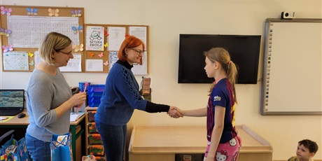 Powiększ grafikę: Pani wicedyrektor w towarzystwie nauczycielki wręcza uczennicy nagrodę .