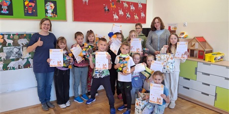 Powiększ grafikę: Zbiorowe zdjęcie uczniów z dyplomami i nagrodami oraz nauczycielki w świetlicy szkolnej.