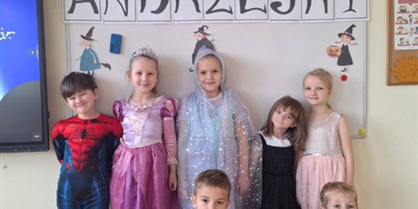 Powiększ grafikę: Zbiorowe zdjęcie uczniów w przebraniach andrzejkowych w sali lekcyjnej.