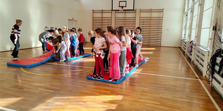 Powiększ grafikę: Uczniowie podczas zabaw sprawnościowych w sali gimnastycznej.