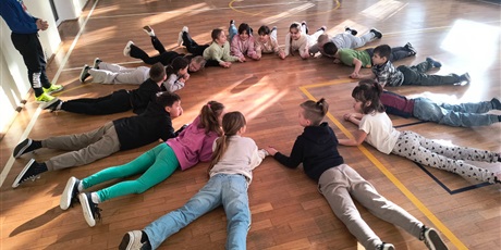 Powiększ grafikę: Uczniowie podczas zabawy integracyjnej w sali gimnastycznej.