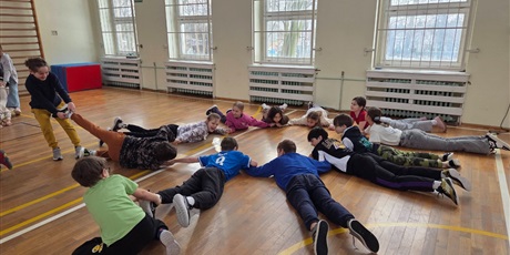 Powiększ grafikę: Uczniowie podczas zabawy integracyjnej w sali gimnastycznej.