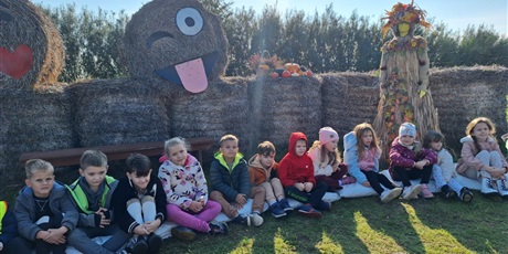 Powiększ grafikę: Zbiorowe zdjęcie uczniów podczas zajęć w zagrodzie wiejskiej.