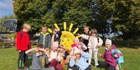 Powiększ grafikę: Zbiorowe zdjęcie uczniów podczas zajęć w zagrodzie wiejskiej.