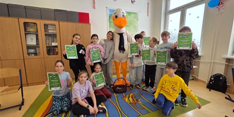Powiększ grafikę: Zdjęcie zbiorowe uczniów podczas zajęć ekologicznych z maskotką programu  w sali lekcyjnej.