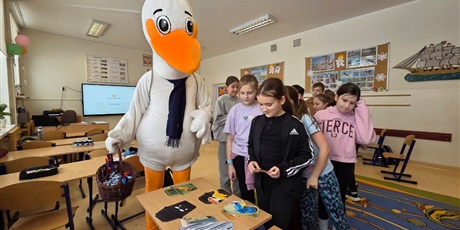 Powiększ grafikę: Uczniowie oraz maskotka programu podczas zajęć ekologicznych  w sali lekcyjnej.