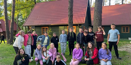 Powiększ grafikę: Uczniowie przed domkami na terenie ośrodka wczasowego