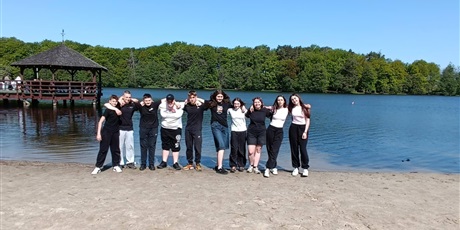 Powiększ grafikę: Zbiorowe zdjęcie uczestników wycieczki na plaży nad jeziorem