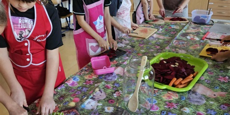 Powiększ grafikę: Uczniowie w sali lekcyjnej przygotowują zdrowe posiłki.