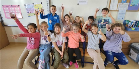 Powiększ grafikę: Uczniowie w sali lekcyjnej demonstrują przygotowane przez siebie produkty.