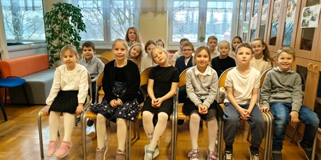 Powiększ grafikę: Pani dyrektor i uczniowie podczas pasowania na czytelnika w bibliotece szkolnej.