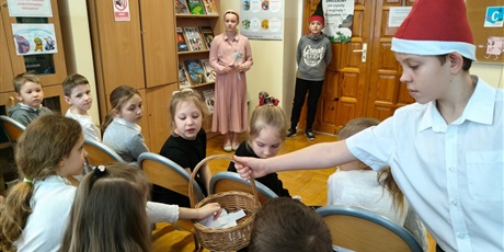 Powiększ grafikę: Uczniowie podczas pasowania na czytelnika w bibliotece.