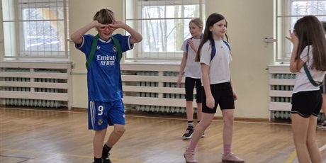 Powiększ grafikę: Uczniowie podczas gry w piłkę nożną w sali gimnastycznej.