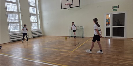 Powiększ grafikę: Uczniowie podczas gry w piłkę nożną w sali gimnastycznej.